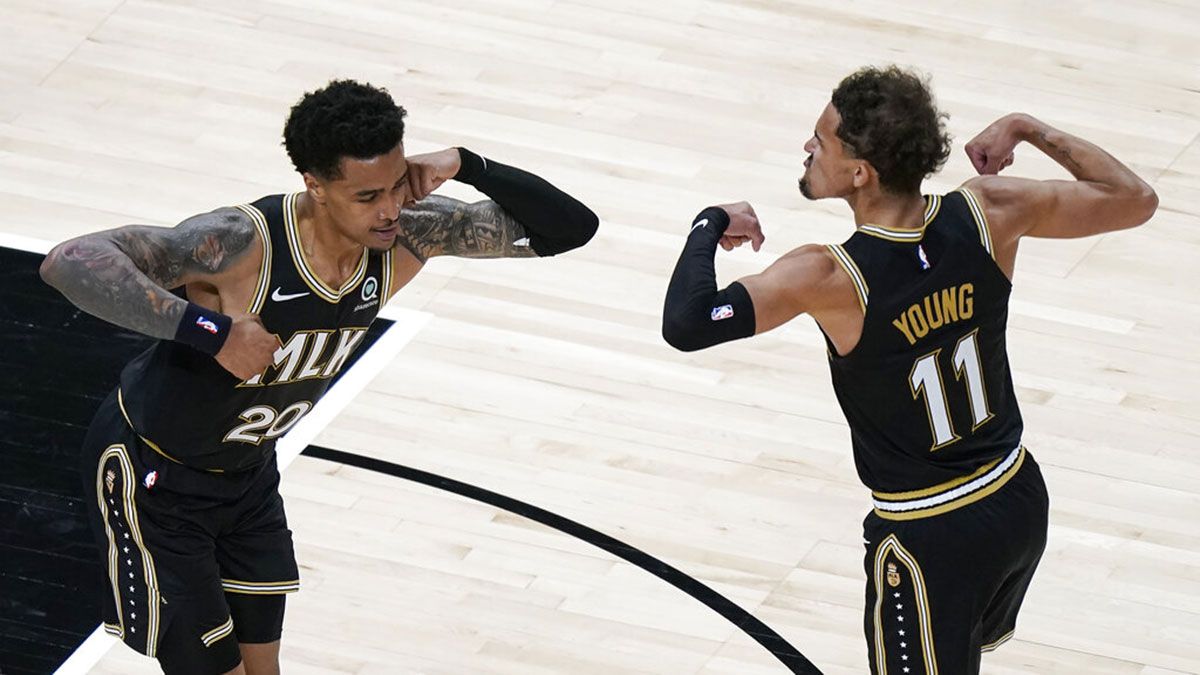 Trae Young John Collins celebrate on court during an Atlanta Hawks game 