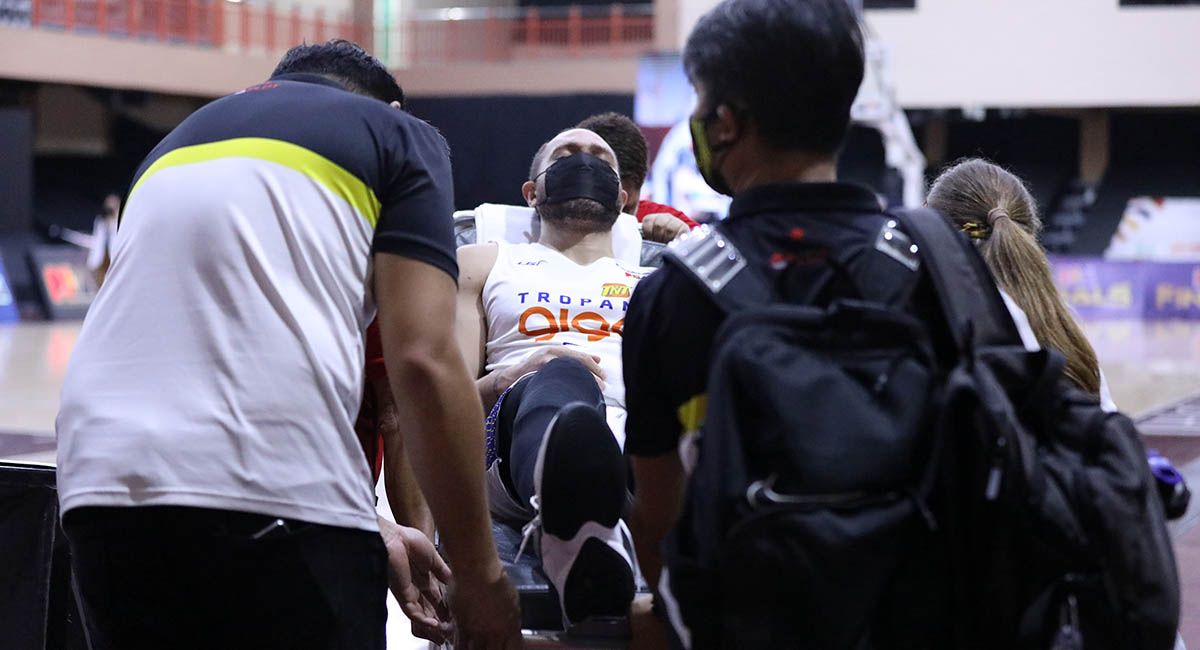 TnT's Kelly Williams is taken out of the DHVSU gym in a stretcher after hurting his back in Game One.