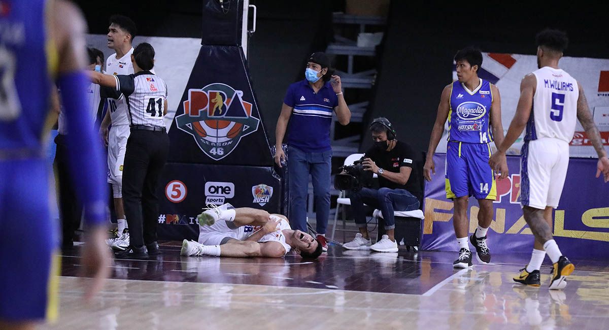 TnT forward Troy Rosario grimaces in pain on the floor after a flagrant foul called on Magnolia forward Jackson Corpuz. 