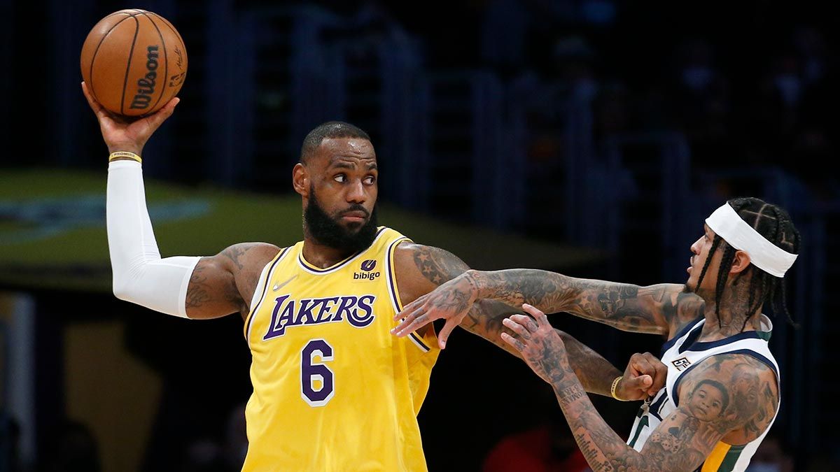 Lakers star LeBron James keeps the ball out of the reach of Utah guard Jordan Clarkson.