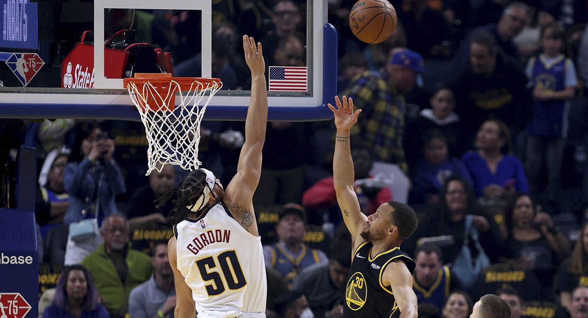 Steph Curry lofts a layup over the outstretched hand of Aaron Gordon.